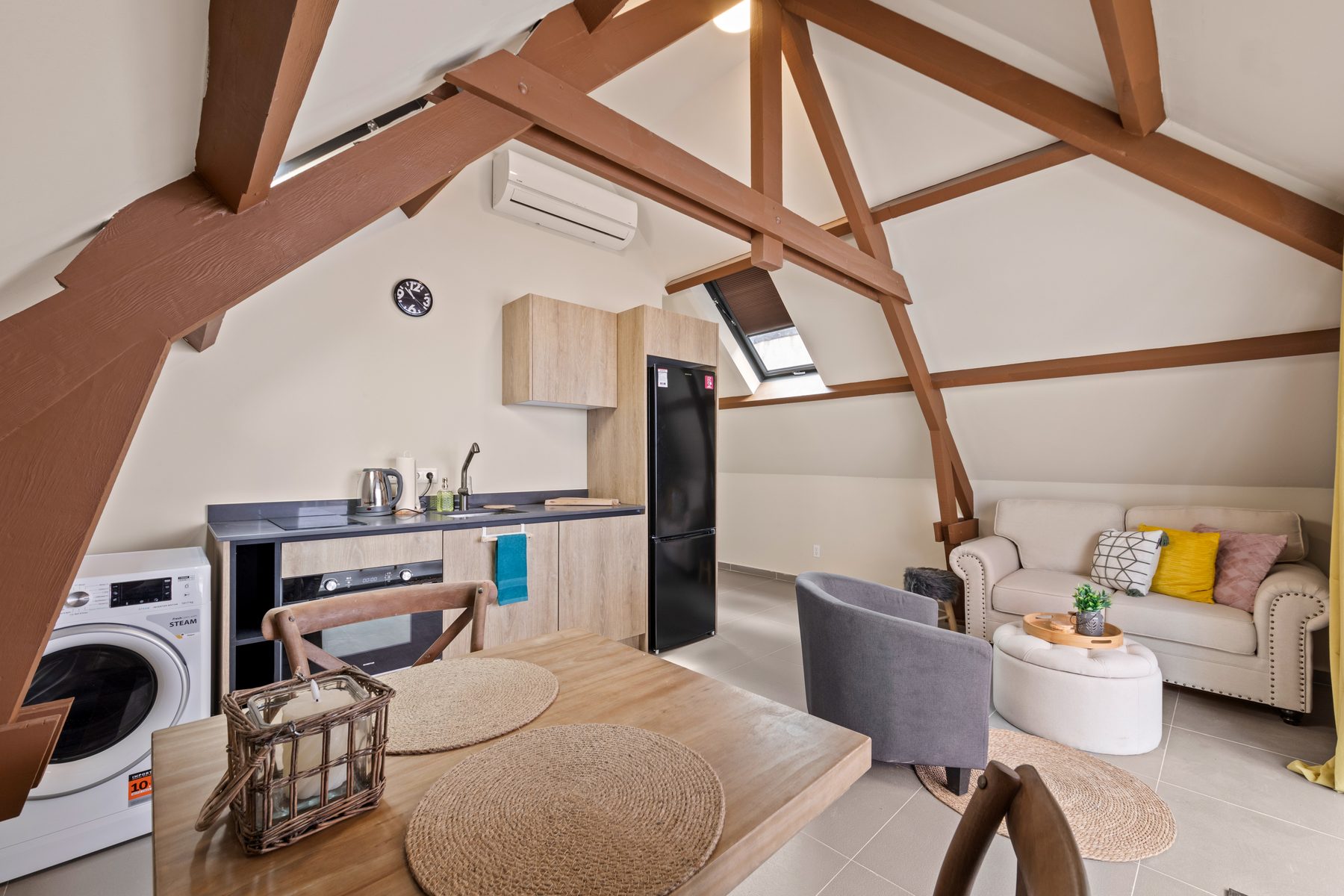 Inside the loft, the original roof trusses framing a contemporary kitchen and living space