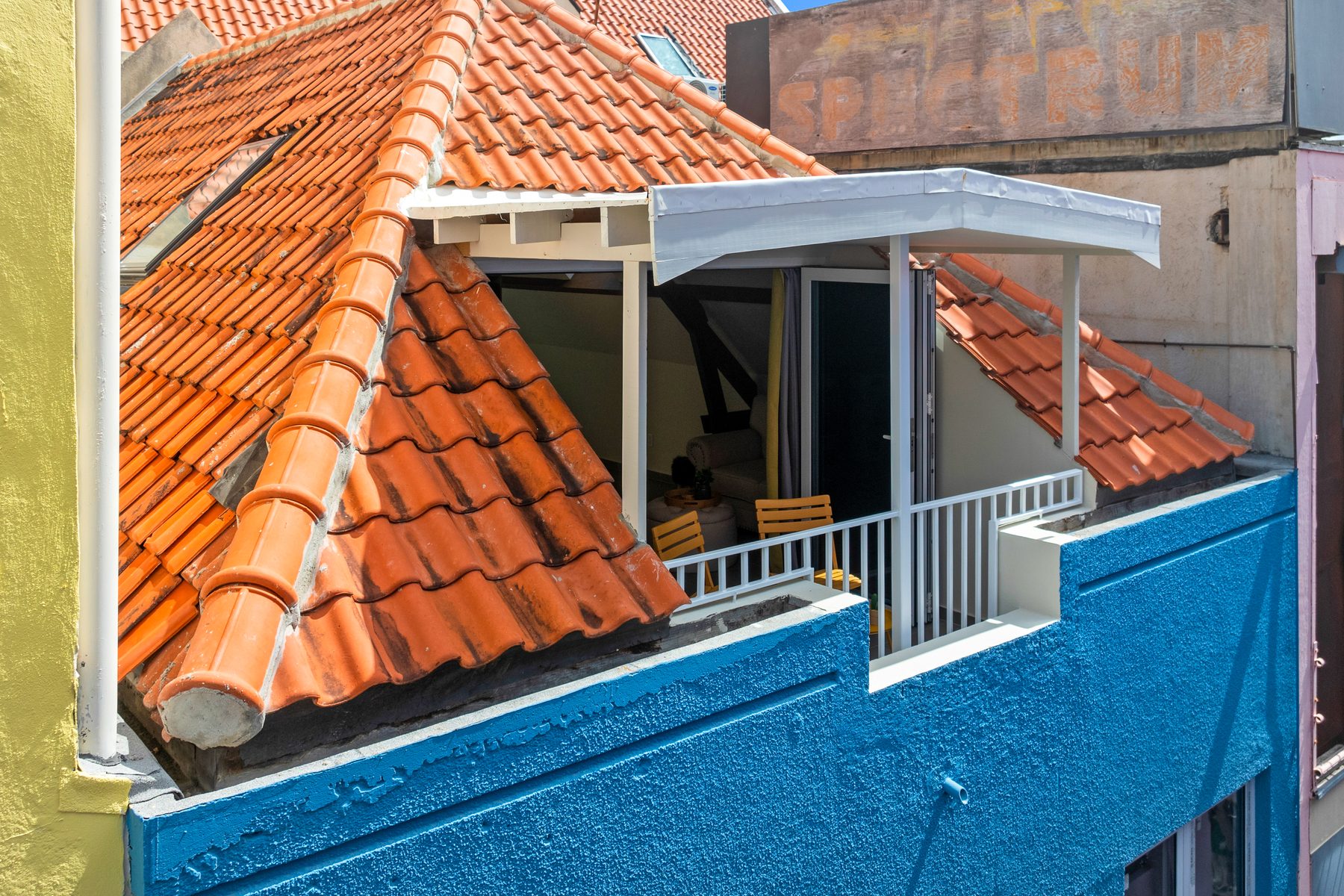 Aerial of red-tiled Willemstad rooftops meeting the Caribbean sea